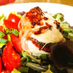 Gebackener Mozzarella mit Schinken und Tomatenmark auf Salatbett
